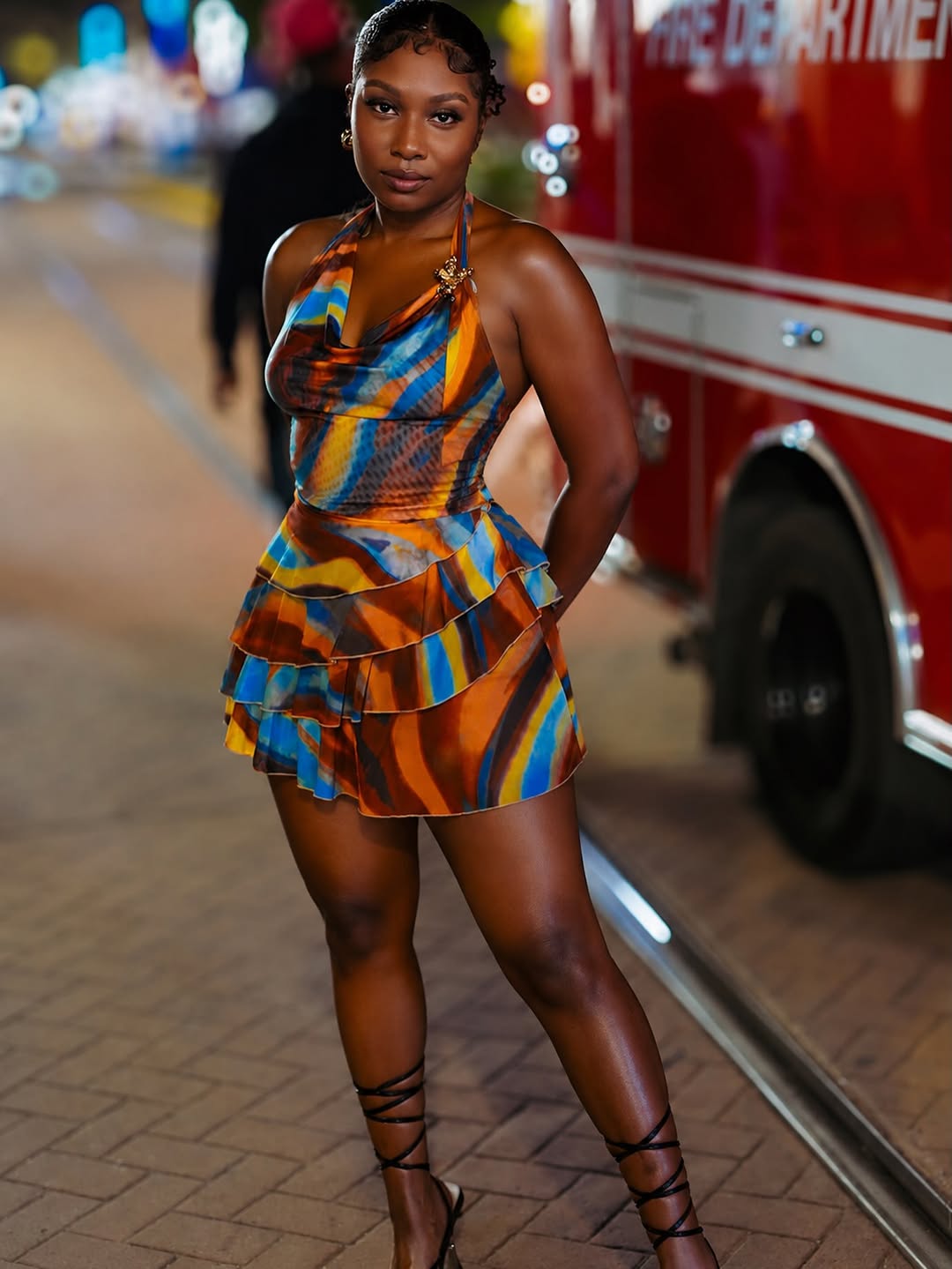 Ashliee in a colorful evening mini dress on a city night street